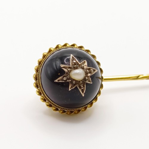 565 - A 19th century yellow metal, engraved cabochon cut purple stone and pearl stick pin  Provenance:  Fr... 