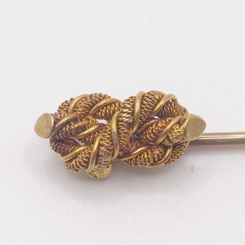 562 - A late 19th/early 20th century yellow metal stick pin, in the form of a knot Provenance:  From a sin... 