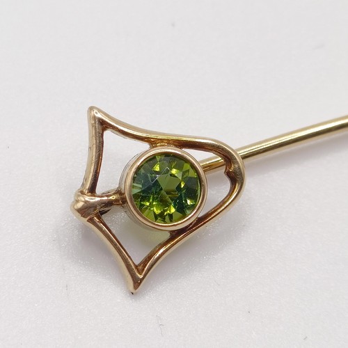 561 - A yellow metal and peridot stick pin  Provenance:  From a single owner collection of Victorian, Edwa... 