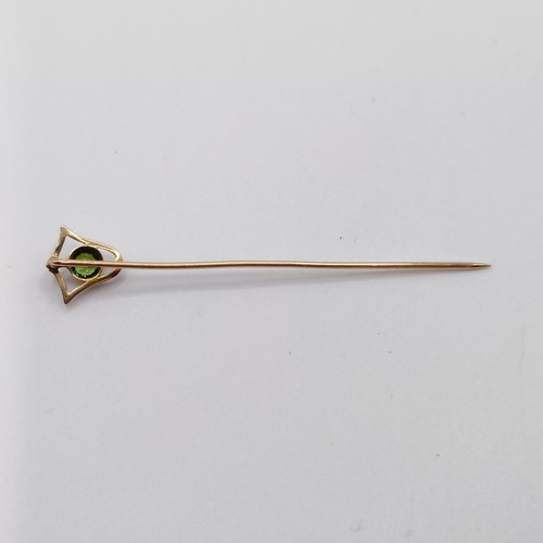 561 - A yellow metal and peridot stick pin  Provenance:  From a single owner collection of Victorian, Edwa... 