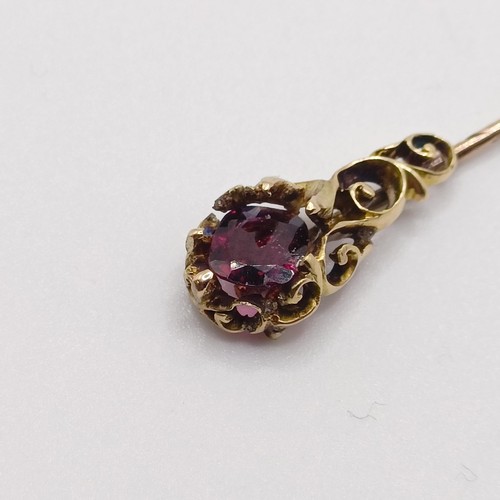 558 - A late 19th/early 20th century yellow metal and garnet stick pin   Provenance:  From a single owner ... 