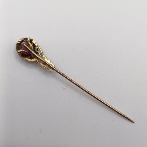 558 - A late 19th/early 20th century yellow metal and garnet stick pin   Provenance:  From a single owner ... 