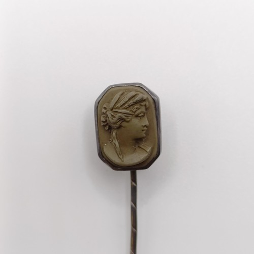 555 - A 20th century silver coloured metal stick pin, inset with lava stone cameo, decorated lady   Proven... 