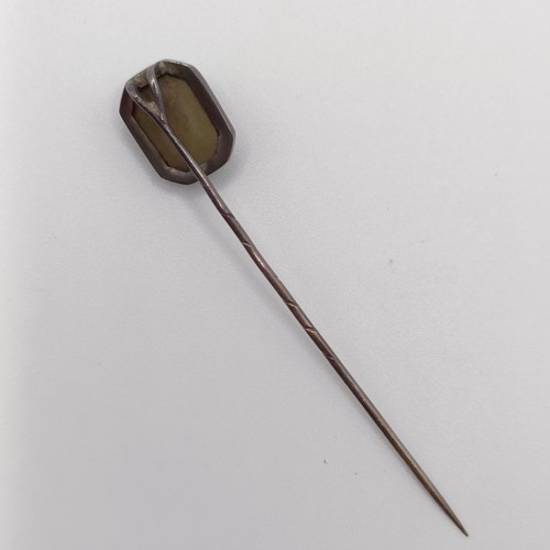 555 - A 20th century silver coloured metal stick pin, inset with lava stone cameo, decorated lady   Proven... 