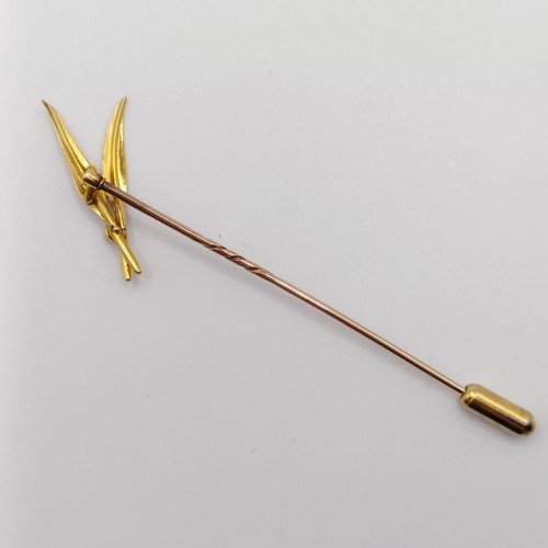 554 - A 20th century yellow metal and diamond stick pin, in the form of two feathers  Provenance:  From a ... 