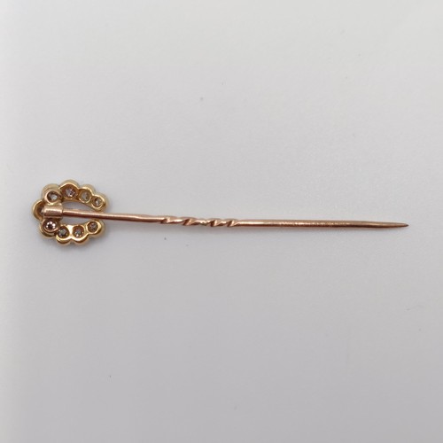 552 - A late 19th/early 20th century yellow metal and diamond stick pin, in the form of a horseshoe  Prove... 