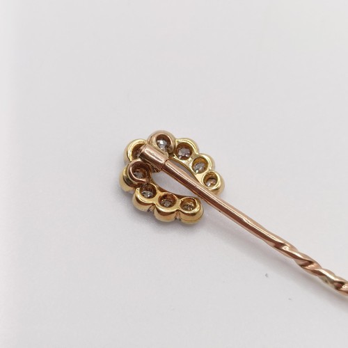 552 - A late 19th/early 20th century yellow metal and diamond stick pin, in the form of a horseshoe  Prove... 