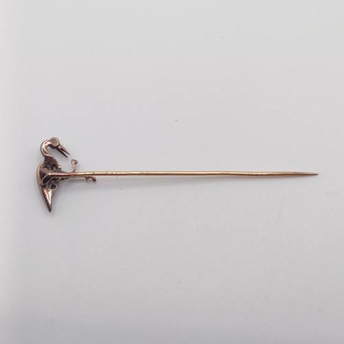 551 - A late 19th/early 20th century yellow metal, red and white stone stick pin, in the form of a bird  P... 