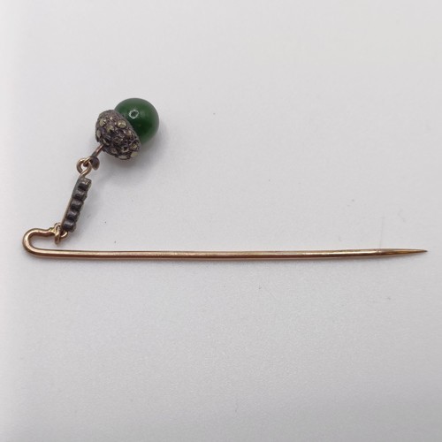 549 - A late 19th/early 20th century yellow metal white stone and green stone stick pin, in the form of an... 