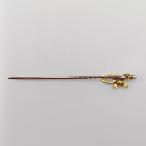 546 - An early 20th century yellow coloured metal and multi-coloured stone stick pin, in the form of a flo... 