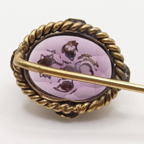 542 - A late 19th/early 20th century yellow metal and engraved purple stone stick pin  Provenance:  From a... 