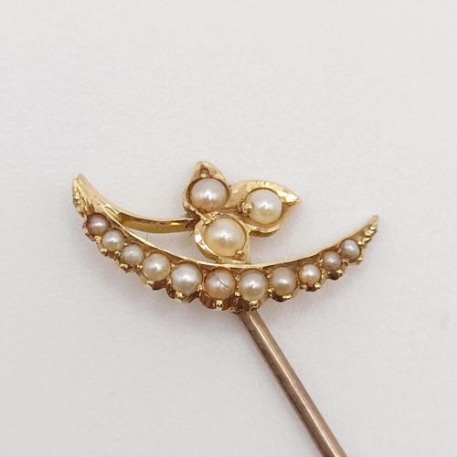 537 - An early 20th century yellow metal and seed pearl stick pin, in the form of a leaf and a cresent  Pr... 