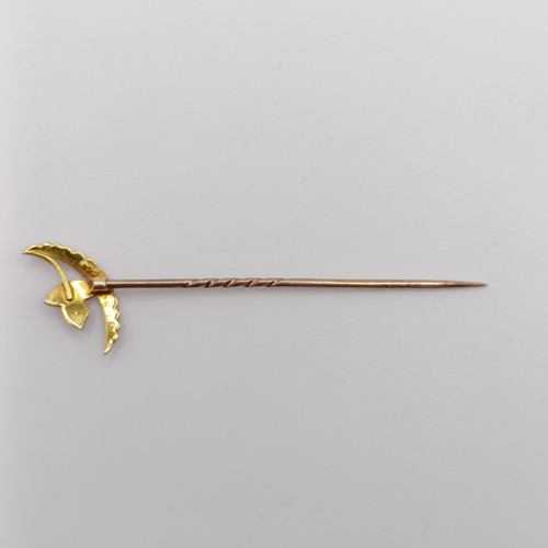 537 - An early 20th century yellow metal and seed pearl stick pin, in the form of a leaf and a cresent  Pr... 