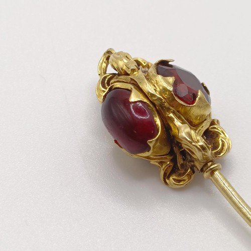 536 - A late 19th/early 20th century yellow metal and red stone stick pin  Provenance:  From a single owne... 