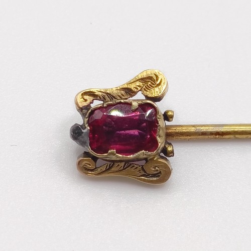 527 - A late 19th/early 20th century yellow metal and garnet stick pin  Provenance:  From a single owner c... 