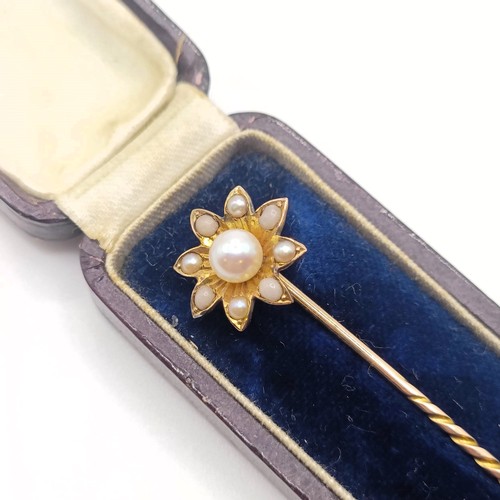 517 - An early 20th century yellow metal and pearl stick pin, in the form of a flower, in a vintage jewell... 