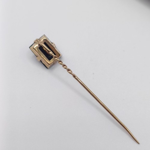 515 - An early 20th century yellow metal and black stone stick pin, initialled with the letter H  Provenan... 