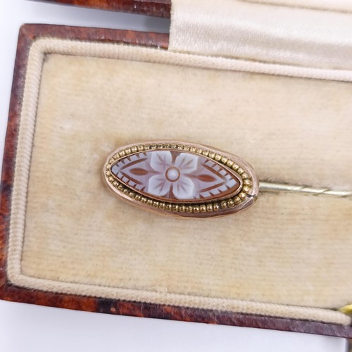 509 - A late 19th/early 20th century stick pin, inset with cameo, decorated flower, in a vintage jewellery... 