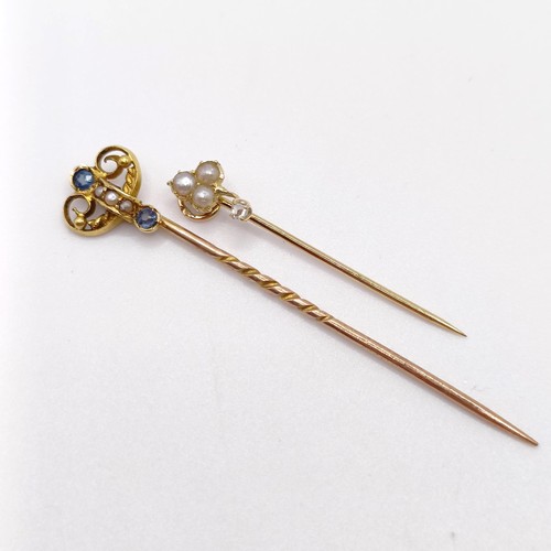 662 - An early 20th century yellow metal, sapphire and seed pearl stick pin, and an early 20th century yel... 