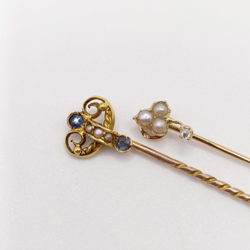 662 - An early 20th century yellow metal, sapphire and seed pearl stick pin, and an early 20th century yel... 