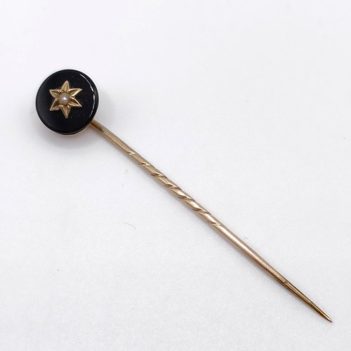 657 - A late 19th/early 20th century yellow coloured metal engraved black stone and seed pearl stick pin P... 