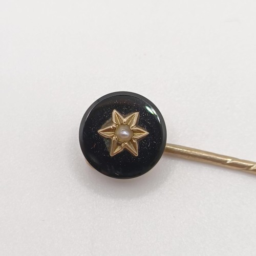 657 - A late 19th/early 20th century yellow coloured metal engraved black stone and seed pearl stick pin P... 