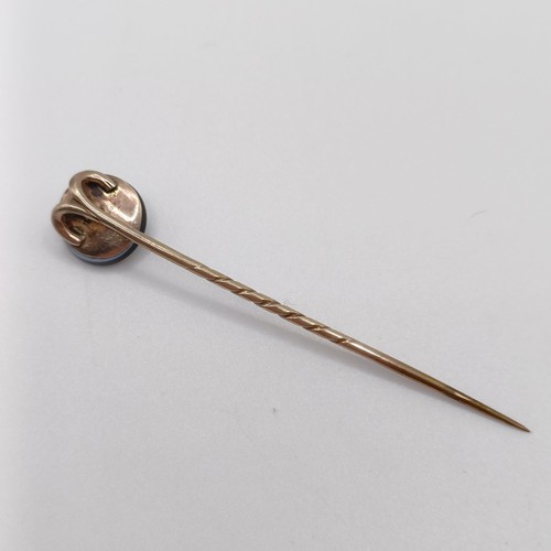 657 - A late 19th/early 20th century yellow coloured metal engraved black stone and seed pearl stick pin P... 