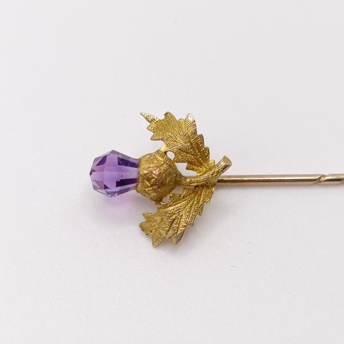 656 - A late 19th/early 20th century yellow metal and amethyst stick pin, in the form of a thistle  Proven... 