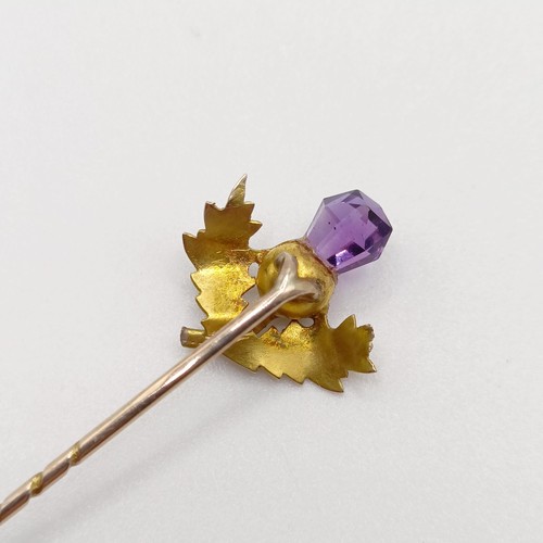 656 - A late 19th/early 20th century yellow metal and amethyst stick pin, in the form of a thistle  Proven... 