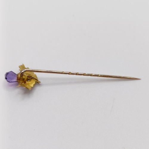 656 - A late 19th/early 20th century yellow metal and amethyst stick pin, in the form of a thistle  Proven... 