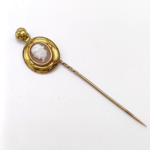 655 - A 19th century yellow coloured metal and glass cameo stick pin, decorated portrait of a man   Proven... 