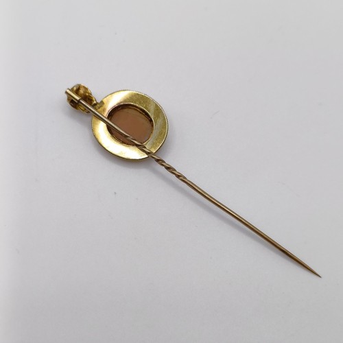 655 - A 19th century yellow coloured metal and glass cameo stick pin, decorated portrait of a man   Proven... 