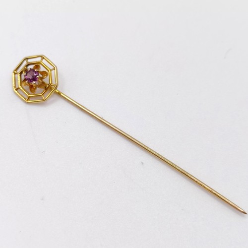 654 - A 20th century yellow coloured metal and purple stone stick pin  Provenance:  From a single owner co... 