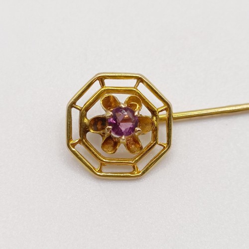 654 - A 20th century yellow coloured metal and purple stone stick pin  Provenance:  From a single owner co... 