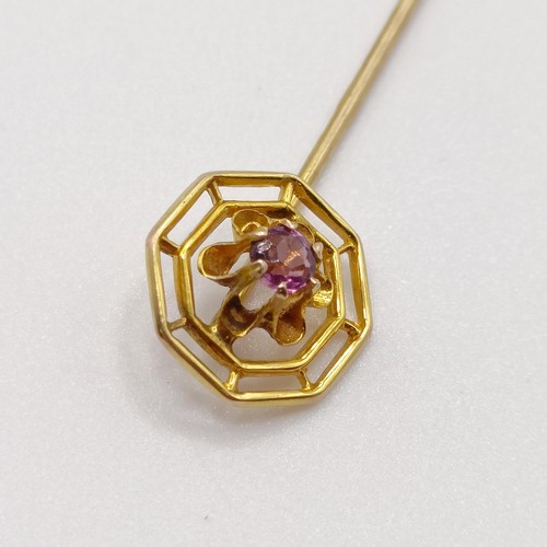 654 - A 20th century yellow coloured metal and purple stone stick pin  Provenance:  From a single owner co... 