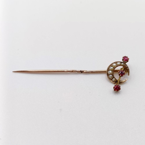 653 - A late 19th/early 20th century yellow metal, seed pearl and red stone stick pin, in the form of a cr... 