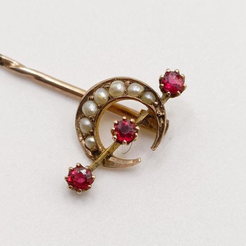 653 - A late 19th/early 20th century yellow metal, seed pearl and red stone stick pin, in the form of a cr... 