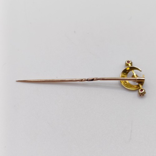 653 - A late 19th/early 20th century yellow metal, seed pearl and red stone stick pin, in the form of a cr... 