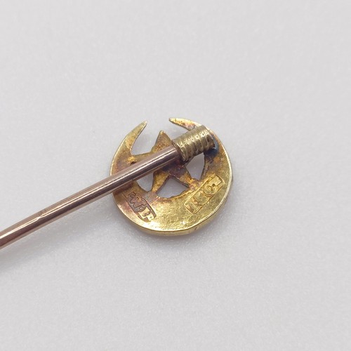 651 - A late 19th/early 20th century yellow metal and seed pearl stick pin, in the form of a crescent moon... 