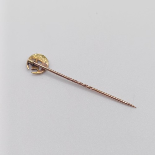 651 - A late 19th/early 20th century yellow metal and seed pearl stick pin, in the form of a crescent moon... 