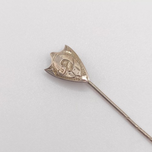 650 - A yellow coloured metal stick pin, in the form of a shield   Provenance:  From a single owner collec... 