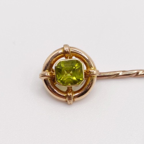 646 - An early 20th century yellow coloured metal and peridot stick pin  Provenance:  From a single owner ... 