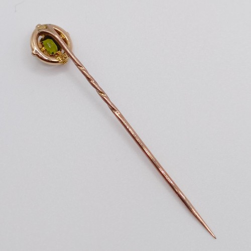 646 - An early 20th century yellow coloured metal and peridot stick pin  Provenance:  From a single owner ... 