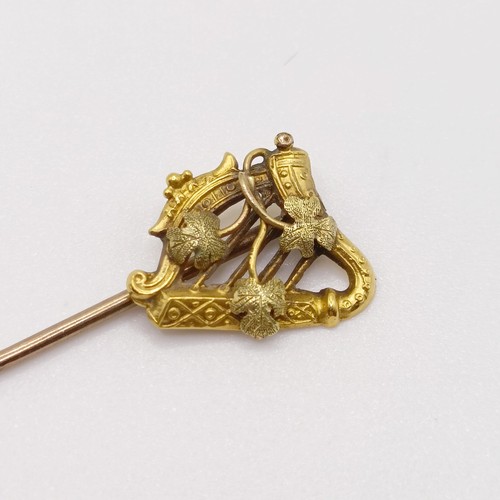 645 - A late 19th/early 20th century yellow coloured metal stick pin, in the form of a harp  Provenance:  ... 