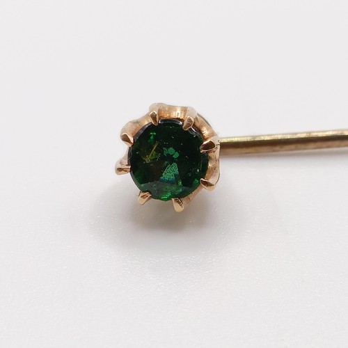 639 - A 20th century yellow coloured metal and green stone stick pin  Provenance:  From a single owner col... 