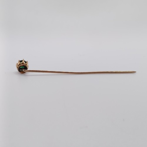 639 - A 20th century yellow coloured metal and green stone stick pin  Provenance:  From a single owner col... 