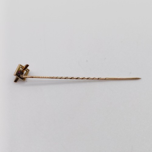 630 - A 20th century yellow coloured metal and red stone stick pin  Provenance:  From a single owner colle... 