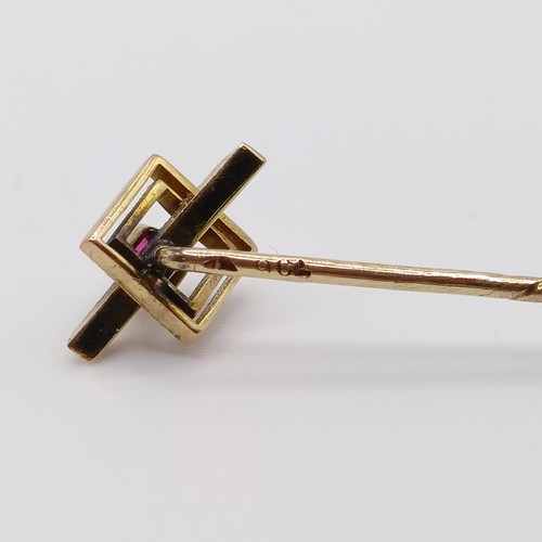 630 - A 20th century yellow coloured metal and red stone stick pin  Provenance:  From a single owner colle... 