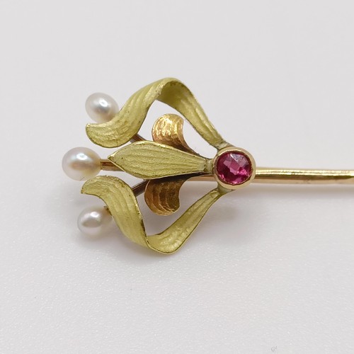 626 - An Art Nouveau yellow coloured metal, green enamel, ruby and pearl stick pin  Provenance:  From a si... 