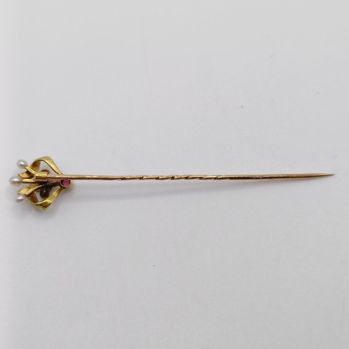 626 - An Art Nouveau yellow coloured metal, green enamel, ruby and pearl stick pin  Provenance:  From a si... 